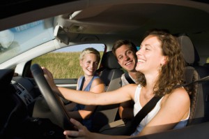 Germany, Bavaria, Young people riding a car, laughing, side view, portrait