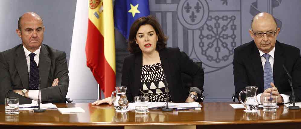 Luis de Guindos, Soraya Sáenz de Santamaría y Cristóbal Montoro en la rueda de prensa del Consejo de Ministros