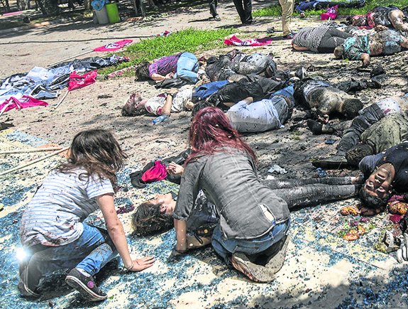 This photo taken on July 20, 2015 shows bodies on the ground after an explosion in the town of Suruc, on July 20, 2015, not far from the Syrian border. At least 20 people were killed and dozens injured, with the origin of the explosion not immediately determined, but many authorities and Turkish media claiming the attack to be carried out by a suicide bomber. AFP PHOTO / TURKEY OUT / OZCAN SOYSAL / DEPO PHOTOS