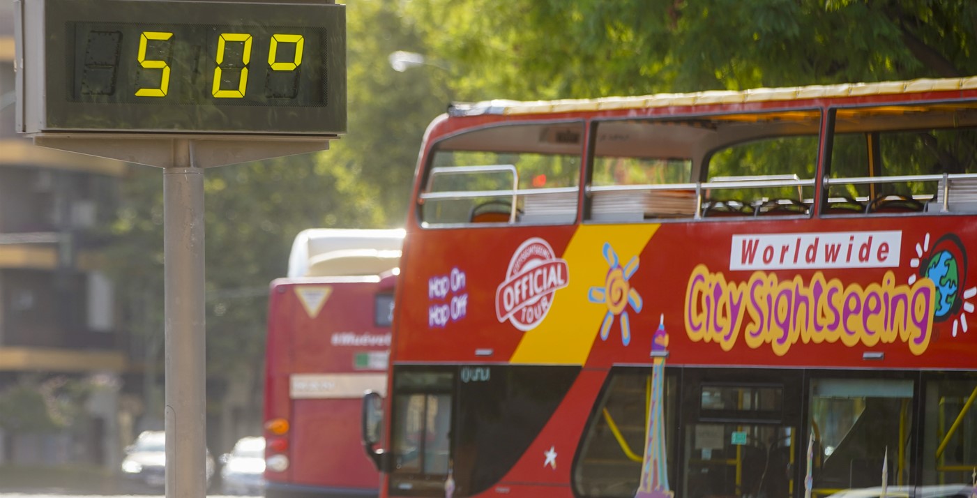 Un autobús turístico pasa delante de un termómetro que marca 5Oº a 25 de julio del 2022 en Sevilla Eduardo Briones / Europa Press